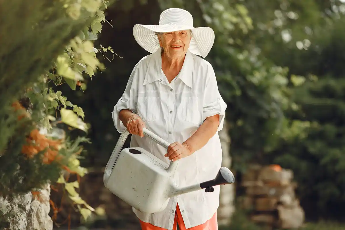 old czech gardener using tools in green garden