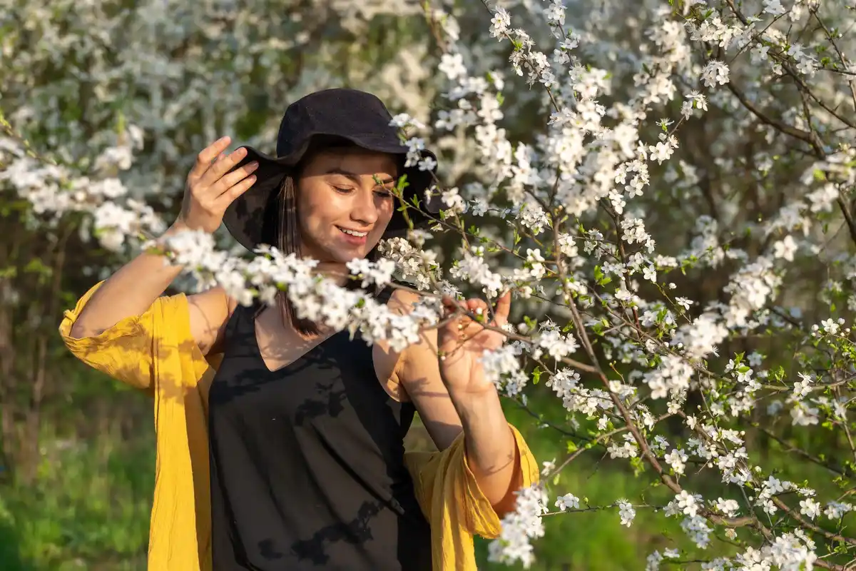 Czech grandmother tending to pear tree in spring garden