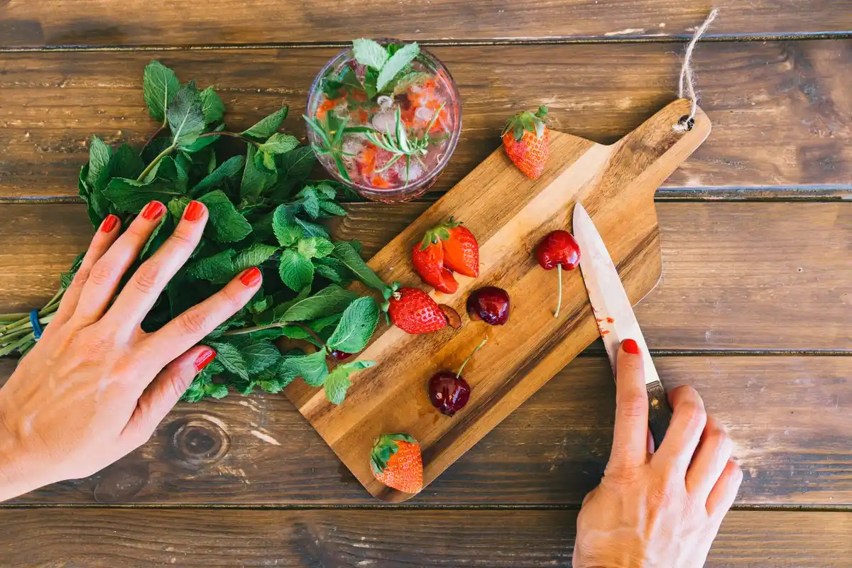 close up hands mulching strawberries with straw in spring