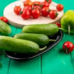 cucumbers and tomatoes side by side in the garden
