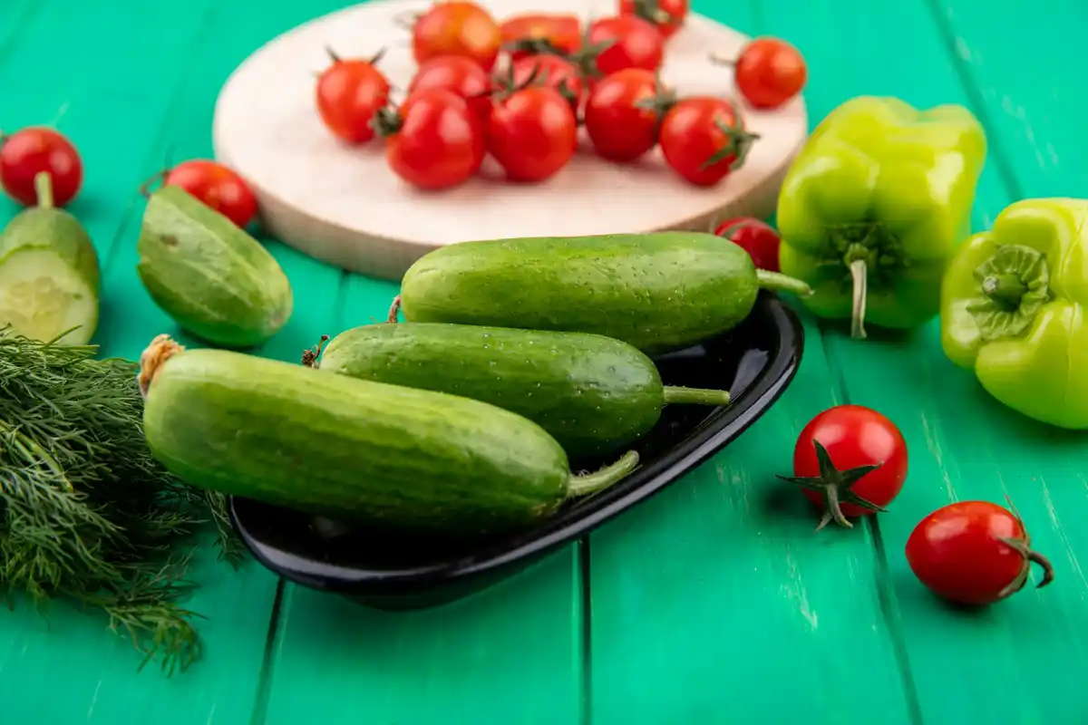 cucumbers and tomatoes side by side in the garden