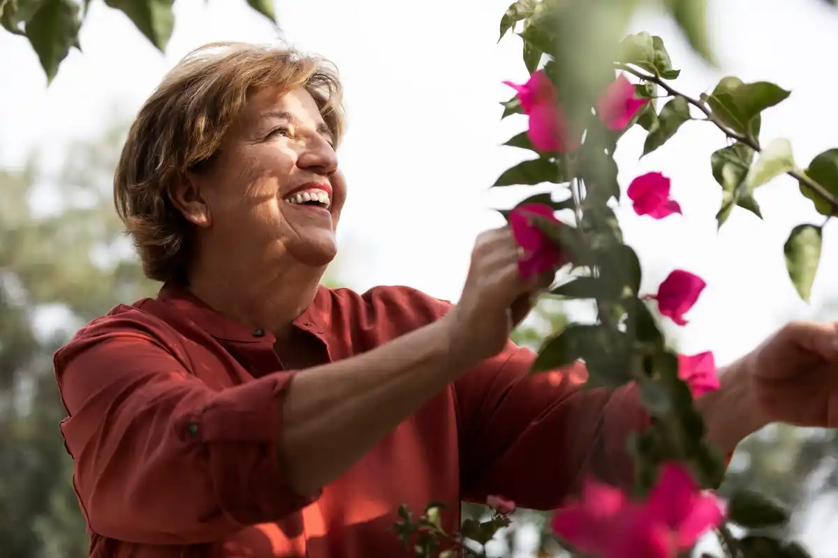 happy senior woman with houseplants Czech