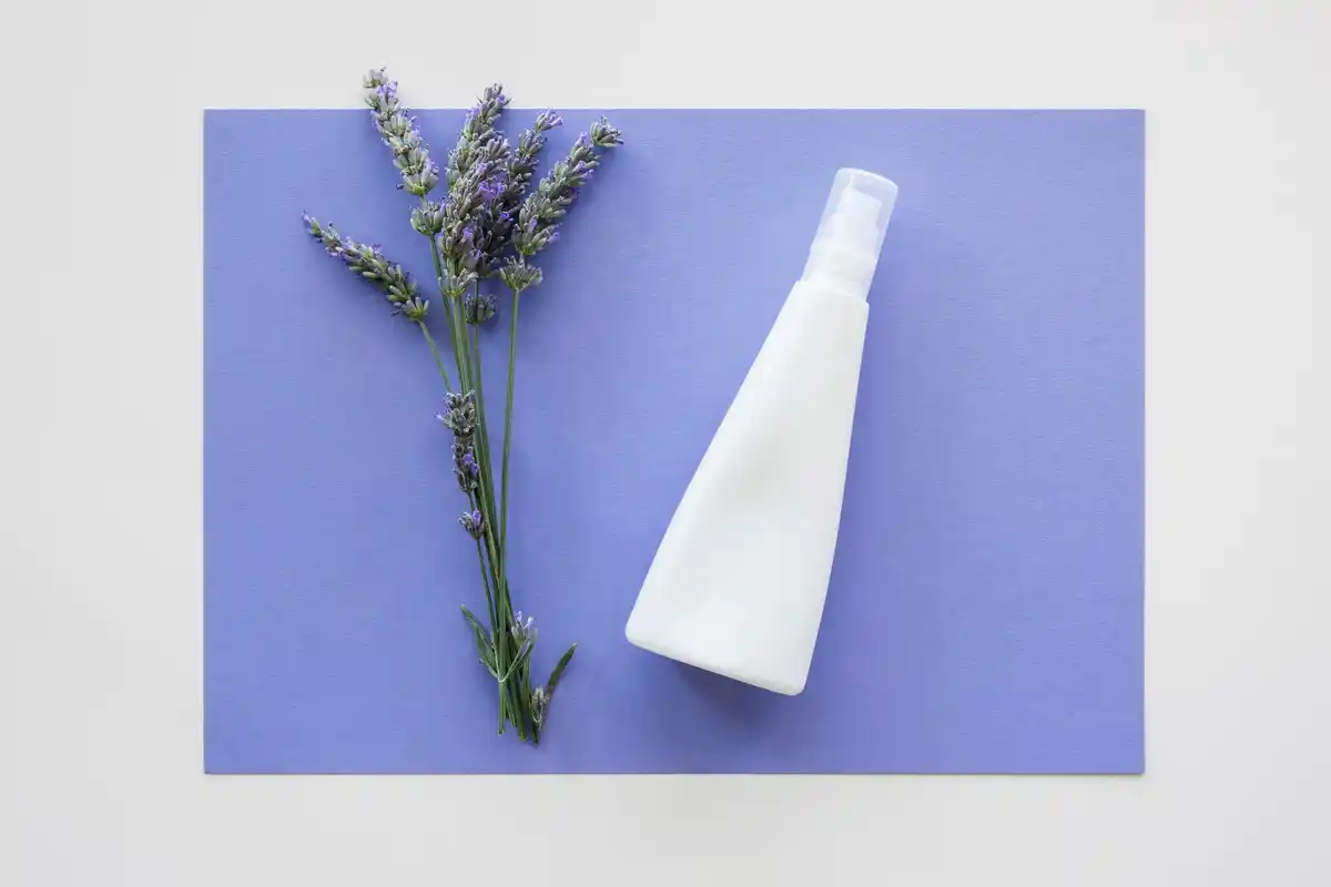 close up of soap flakes and water in spray bottle with green plants