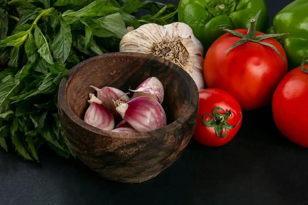 fresh garlic near tomatoes kitchen home gardening prevention