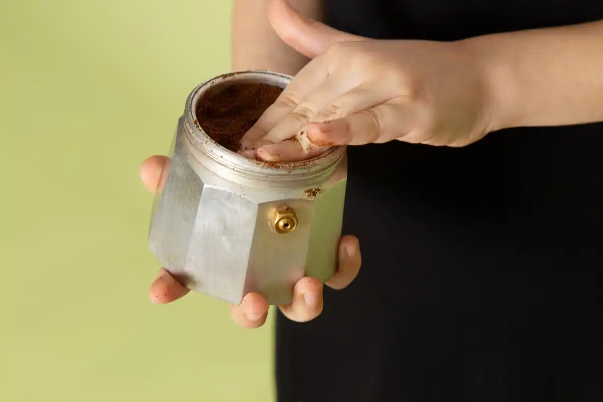 pouring coffee grounds onto garden plants spring