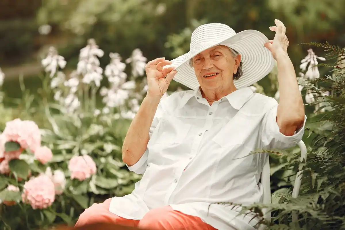 senior woman watering garden lawn Czech summer
